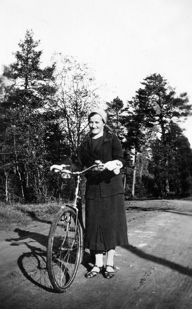 Vanha mustavalkoinen valokuva Oili Linnasta polkupyörineen.